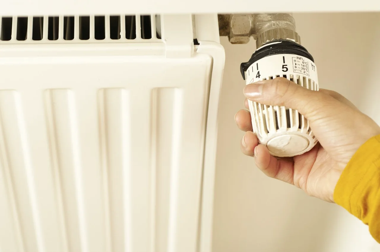 Hand adjusting a thermostatic radiator valve